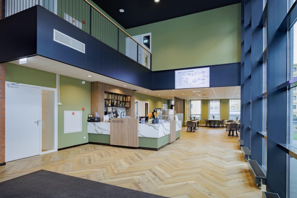 Modern reception area with a coffee counter and seating space in a bright, spacious building on Hiridostraat.